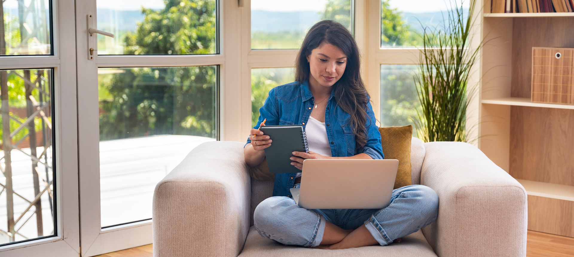 Woman using laptop and tablet on couch