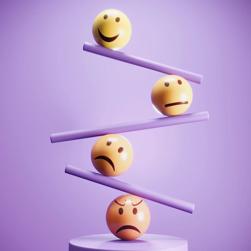 Yellow emoticons on a purple seesaw.